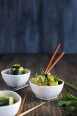 Chilled Pai Huang Gua, Chinese Smashed Cucumber Salad. Made with garlic, ginger, sesame oil, soy sauce and garnished with fresh cilantro leaves. Selective focus with blurred foreground and background.