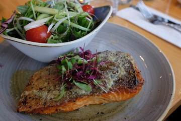 Salmon steak and salad on a table