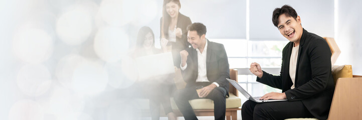 A group of young businessmen in suits, Asians, are determined and excited about their work. and encourage the team members by raising their hands happily web banner with copy space on left