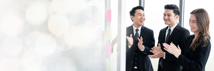 An Asian businessman is presenting his company performance report to his boss or group of male and...