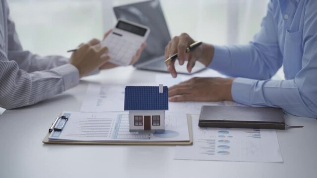 Signing House Rental Contract Document concept, House model with agent and customer discussing for contract to buy, get insurance or loan real estate or property.