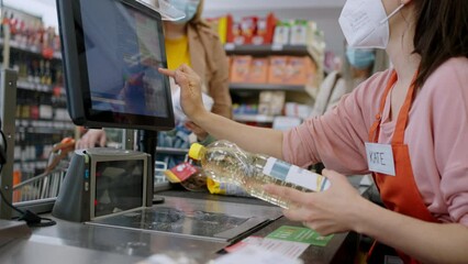 Close-up of little blond girl paying for grocery shopping in supermarket. - Powered by Adobe
