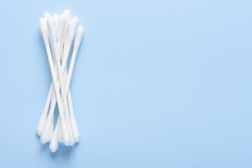 Fototapeta na wymiar White new clean cotton swabs buds on blue background top view flay lay with side copy-space