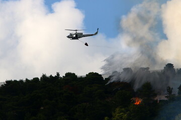 Fototapeta na wymiar A UN helicopter puts out a fire in a forest on the Israel-Lebanon border.
