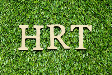Wood alphabet letter in word HRT (Abbreviation of Hormone replacement therapy) on green grass...