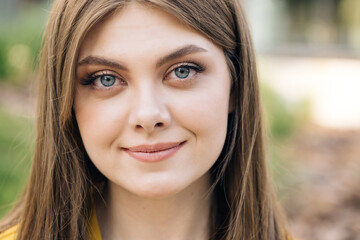 Fototapeta premium Gorgeous young beautiful caucasian long hair woman looks at camera outside business district. Confident girl. Fashion, trendy, girl, urban, outdoor, beauty, smiling, businesswoman