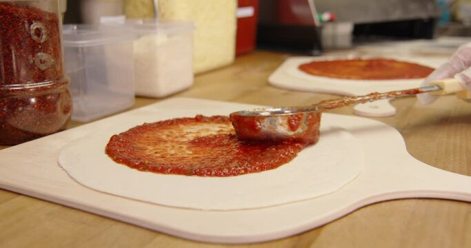 Making fresh pizza the tomato sauce