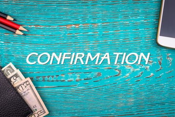 CONFIRMATION - word (text) and money dollars on the table in a notepad, pencils and smartphone...