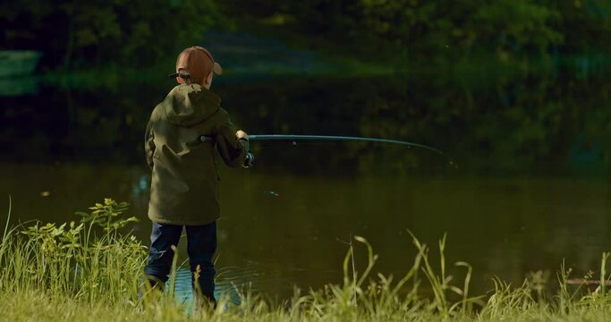schooler boy is casting fishing rod in pond and watching float, catch fish process, 4K, Prores
