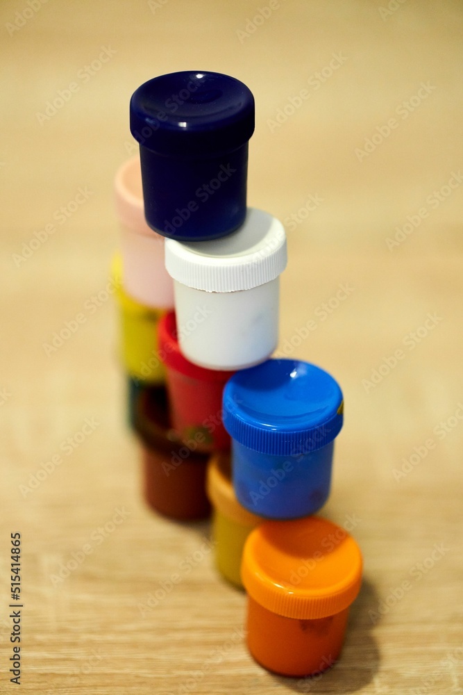 Poster closeup shot of a multicolored set of watercolors containers on a table with blurred background
