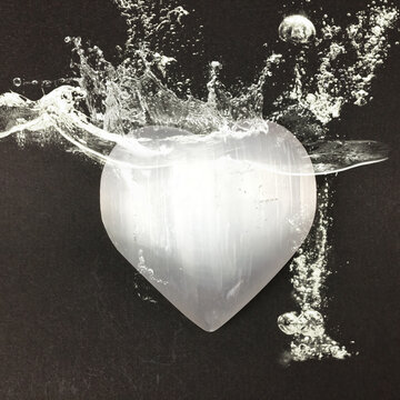 Heart shaped selenite crystal with energy aura and water splashes. Raise your vibration higher with clean pure selenite for well being.