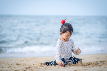 girl playing in the sand by the sea
