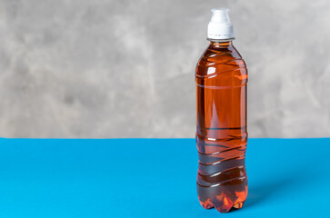 Orange isotonic drink on blue and stone backgrounds. With copy space.