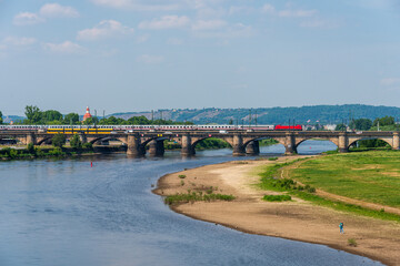 Blick über die Elbwiesen zur Augustusbrücke mit Blick auf Weinberge bei Radebeul, Ein Personenzug überquert die Brücke