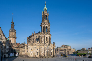 Fototapeta na wymiar Dresden, der Schloßplatz mit Schloß, Hofkirche und Semperoper in morgendlichem Sonnenlicht, eine Straßenbahn fährt vorbei