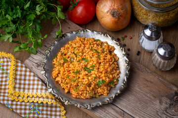 Traditional turkish bulgur pilaf with tomato sause in plate (Turkish name; meyhane pilavi)