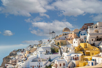 Beautiful view of Oia with traditional white houses and windmills in village, Santorini island,...
