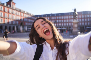 Happy caucasian woman is taking a selfie smiling at the camera in front of the Equestrian Monument...