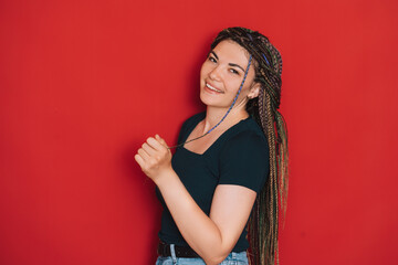 Girl with multi-colored pigtails against a red background.