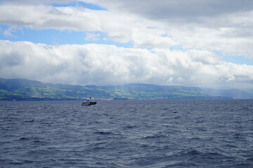 Fototapeta premium Boat sailing over Sao Miguel island, Azores, Portugal