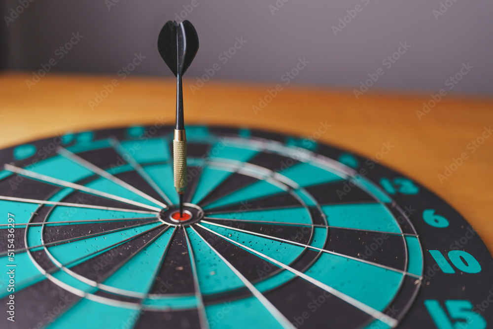 Poster close up shot of the dart arrow hit on bulleyes of dartboard to represent that the business reached 