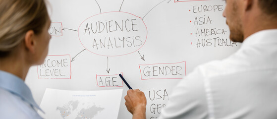 marketing management team working with audience analysis data on whiteboard. market and customer research