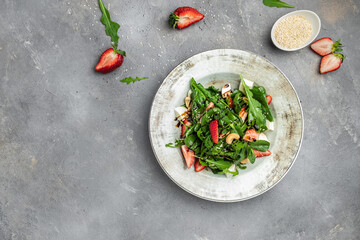 Strawberry salad with spinach, nuts, cheese, Fresh vegetarian salad on gray stone background, banner, menu, recipe place for text, top view