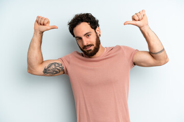 young adult bearded man feeling proud, arrogant and confident, looking satisfied and successful,...