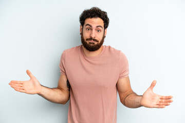 young adult bearded man feeling puzzled and confused, unsure about the correct answer or decision,...