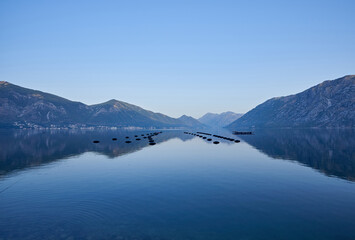 Beautiful morning seascape with mountains reflection in water