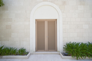 louvered entrance door on the wall with stone finish