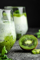 Fototapeta na wymiar Healthy breakfast chia pudding with kiwi in glass jars on a white table. Clean eating, dieting, vegan food concept. vertical image