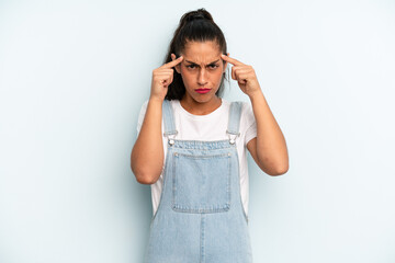 hispanic pretty woman with a serious and concentrated look, brainstorming and thinking about a...