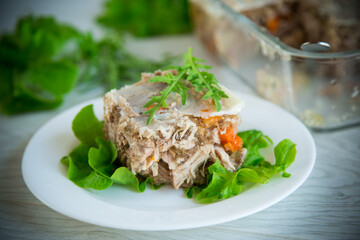 jellied meat with greens and vegetables in a plate