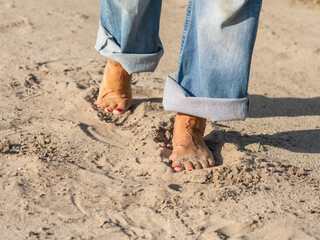Bare feet walking in the sand.
