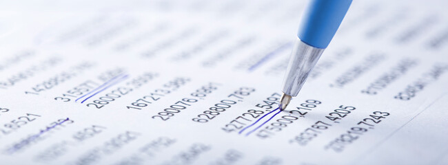 Accounting document with pen, money, coins and checking financial chart. Concept of banking, financial report and financial audit.