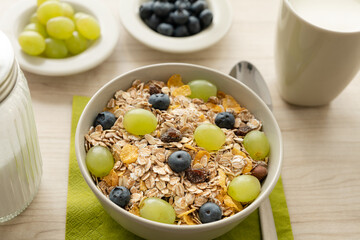 Müsli in Schale mit frischen Weintrauben und Heidelbeeren