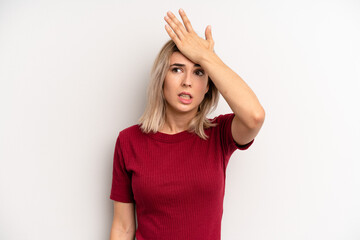 young adult blonde woman raising palm to forehead thinking oops, after making a stupid mistake or...
