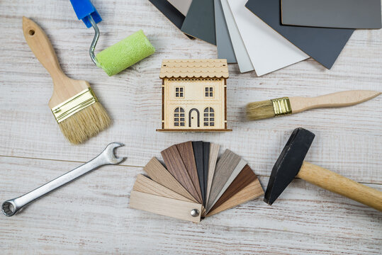 Renovation concept. Wooden house model, tools, paint brushes