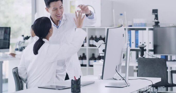 Team of laboratory scientists celebrating with high five gesture after genetic medical research breakthrough in monkeypox cure. Two pathologists, biochemical engineers using a computer and microscope