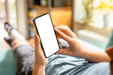 Man using smartphone blank screen frameless modern design while lying on the sofa in home interior