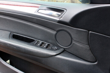 Obraz na płótnie Canvas Door handle with windows controls and adjustments in modern car. Window switches. Driver door trim modern car.