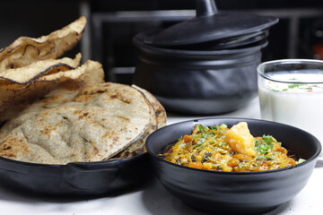 Baigan or Baingan Bharta-Roasted and mashed eggplant is traditional Indian food,served with papad,bajra roti or bhakhri.