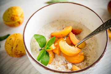 Healthy breakfast of apricot oatmeal with fresh fruit