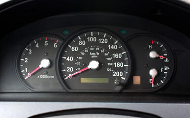 Car Dashboard. Close up image of illuminated car dashboard. Odometer of car. Odometer, speedometer, tachometer, fuel level, water temperature and more.