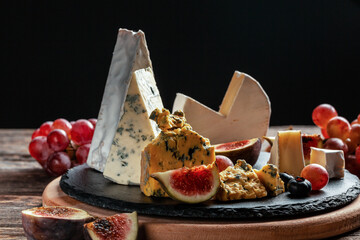 Various kind of cheese, traditional pieces of french, italy and spanish manchego cheese with grapes...
