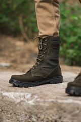 Military man in dark green leather tactical boots