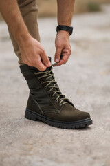 Military man in dark green leather tactical boots