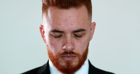Pensive redhair man closin eyes in contemplation and meditation. executive business guy thinking