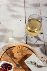 Cheese board served with marmalade and fresh white wine